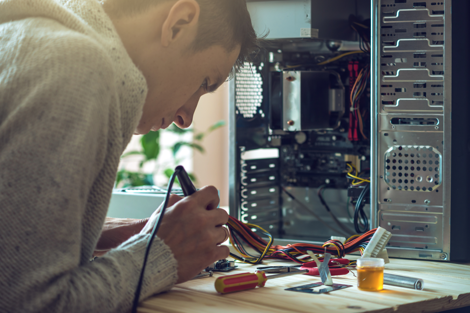 Image of a man repairing computer